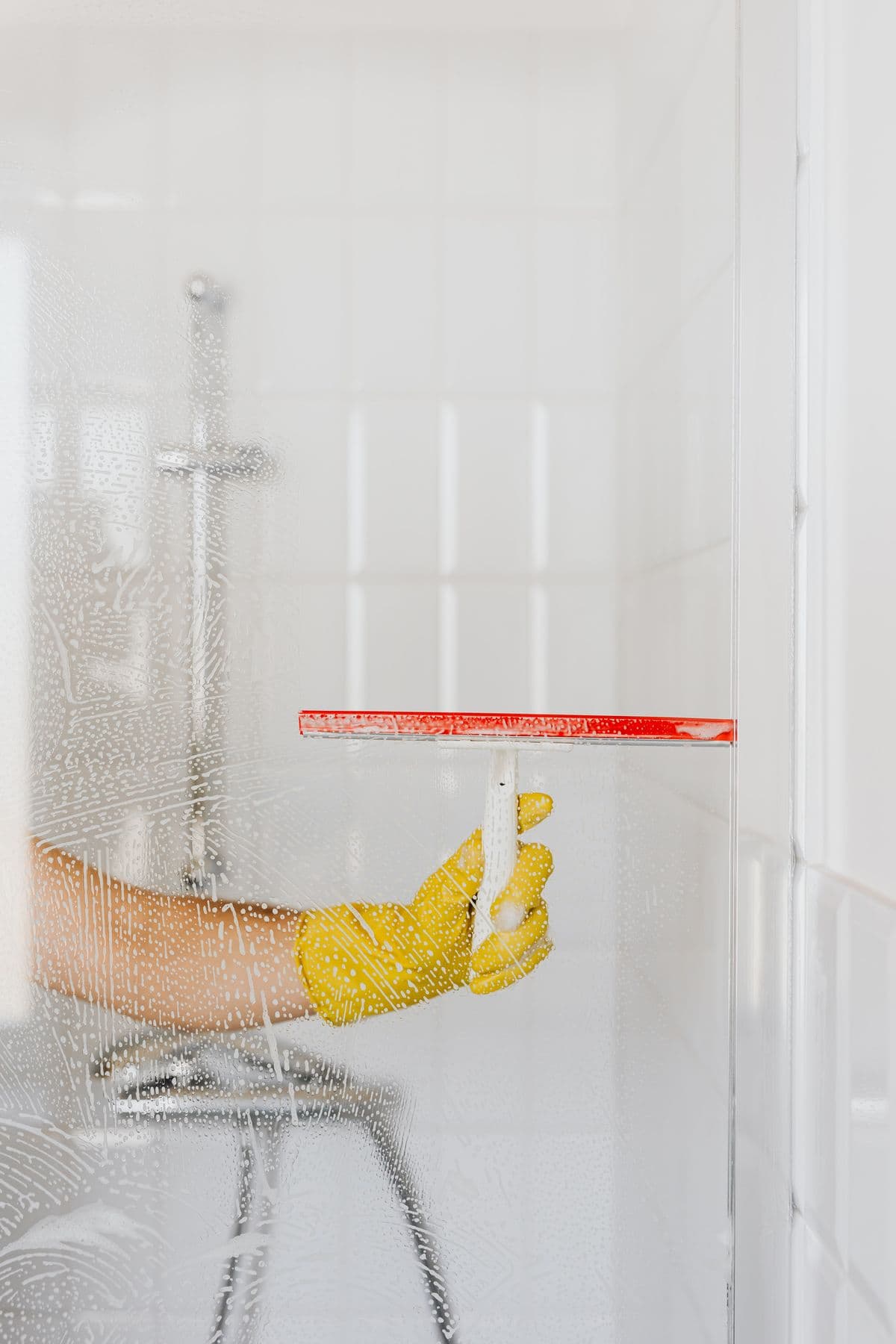 Cleaner squeegeeing a glass shower screen